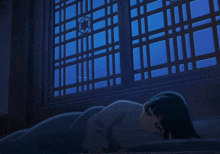 a girl is laying on the floor in front of a blue window