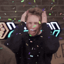 a man with confetti falling on his head and a sign that says ' nc ' on it