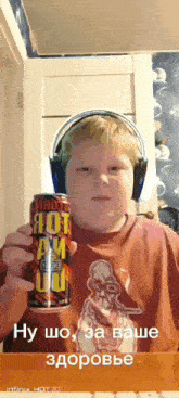 a boy wearing headphones holds up a can of hot am juice