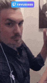 a man with a beard is wearing earbuds and has a twitch icon on his head