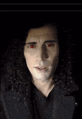 a man with curly hair has red eyes