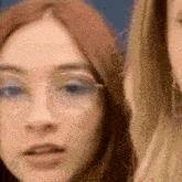 a close up of a woman wearing glasses and a blonde woman wearing glasses .