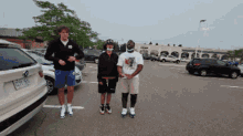 three people standing in a parking lot with a bmw with a license plate that says e2yt rcv