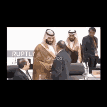 a man in a sheikh 's robe is shaking hands with a man in a suit .