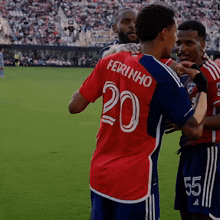 a soccer player wearing a red shirt with the number 20 on the back