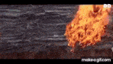 a large fire is coming out of a hole in the ground