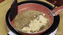 a pan of food is being stirred with a spatula and made in animatica