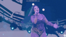 a woman singing into a microphone with the website bandicam.com at the bottom of the screen