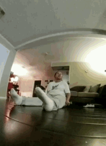 a man is laying on the floor in a living room wearing a shirt that says ' dead '