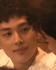 a close up of a man 's face with a woman 's face behind him .
