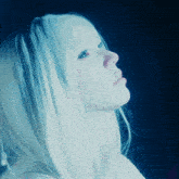 a woman with blonde hair and blue eyes is looking up