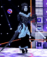 a woman in a black and white polka dot dress is on a stage
