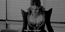 a black and white photo of a woman wearing a costume and a necklace .
