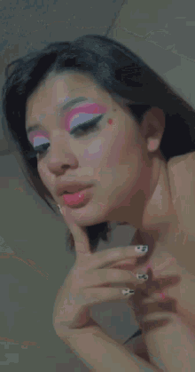 a close up of a woman 's face with pink and white makeup on .