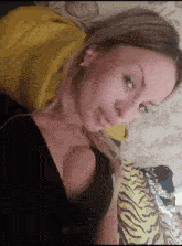 a woman is laying on a bed with a yellow pillow