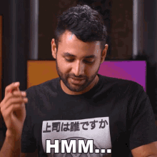 a man wearing a black shirt that says hmm