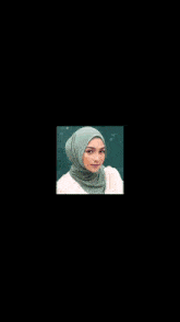 a woman wearing a green hijab is surrounded by sparkly lights on a black background