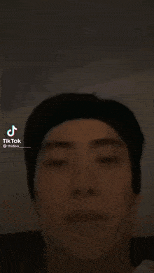 a close up of a man 's face with a tik tok logo on the bottom