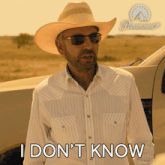 a man wearing a cowboy hat and sunglasses says i don t know