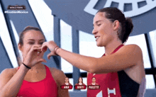 two female athletes are making a heart shape with their hands in front of a screen that says exatlon mexico