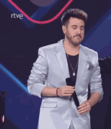a man in a suit is holding a microphone in front of a rtv logo