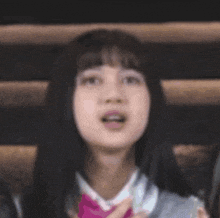 a close up of a woman with her mouth open and her hand on her chin .