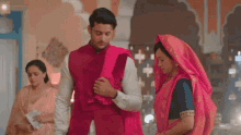 a man and a woman are standing next to each other in a room .