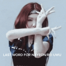 a woman with red hair is making a peace sign with her hands while wearing a headband .