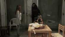 a man and two women standing around a table with a basket on it