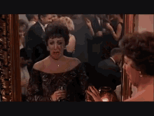 a woman is looking at herself in a mirror and crying .