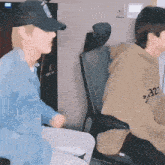 a man wearing a hoodie with the number 32 on it sits next to another man