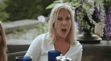 a woman is sitting at a table with her mouth wide open