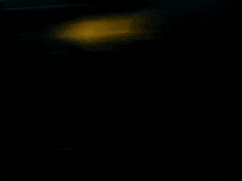 a blurry picture of a person 's face with a yellow object in the background