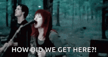a woman is singing into a microphone while a man plays a guitar in a band .