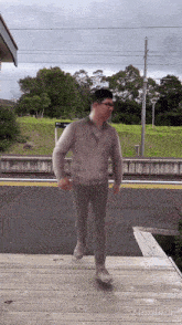 a blurry picture of a man walking on a wooden deck with a sign in the background that says ' sydney '