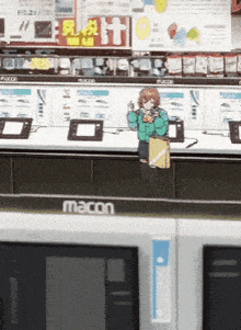a macon store display with a girl standing in front of it