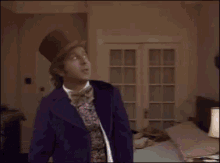 a man in a purple jacket and bow tie is standing in a bedroom holding a sword .