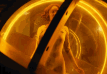 a woman in a white suit is standing in a glowing yellow room