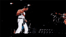 a man is singing into a microphone while dancing on a stage