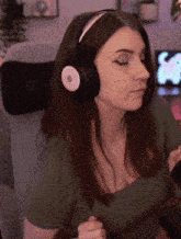 a woman wearing headphones is sitting in a chair and looking down