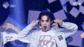 a group of people are performing on a stage with a mnet logo in the corner