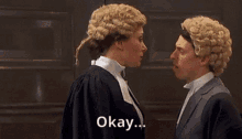 a man and a woman in wigs are standing next to each other and the woman says okay .