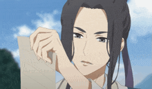 a girl with long hair is holding a piece of paper