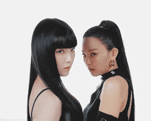 two women with long black hair are standing next to each other and looking at the camera