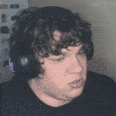 a man with curly hair wearing headphones has the hashtag @matchu on the bottom right