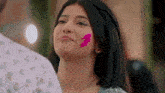 a close up of a woman 's face with pink powder on it .
