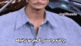 a man with a mustache is wearing a blue shirt with arabic writing on it .