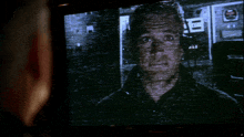 a man 's face is projected on a pioneer television