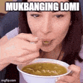 a woman is eating a bowl of soup with a spoon and the caption mukbanging lomi