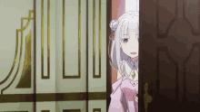 a girl in a pink dress stands in a doorway